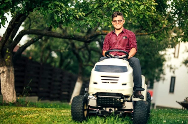 Man Smiling while moxing the the grass because he is an owner operator for 99 Lawn Care!